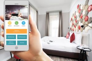 osoba trzymająca telefon, by zrobić zdjęcie pokoju hotelowego w obiekcie Three Corners Hotel Art w Budapeszcie