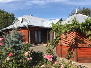 una casa con una valla y flores en el patio en Прикарпаття en Kosiv