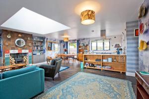 a living room with blue furniture and a dining room at Big Sky in Camber