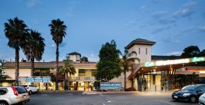 un parcheggio con auto parcheggiate davanti a un edificio di Nightcap at Ferntree Gully Hotel Motel a Fern Tree Gully