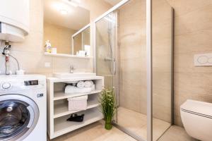 ein Bad mit einer Dusche und einer Waschmaschine in der Unterkunft VSG Resort - Apartments 200m from Beach, Pool, Sauna & Jacuzzi in Klimno