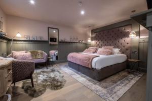 a bedroom with a large bed and two chairs at The Three Blackbirds in Stetchworth