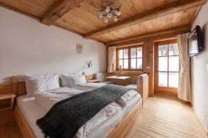 - une chambre avec un lit dans une pièce dotée de plafonds en bois dans l'établissement Villa al Bosco, à Selva di Val Gardena