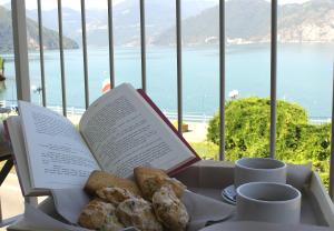 um livro sobre uma mesa com donuts e chávenas de café em Hotel Capovilla em Pisogne