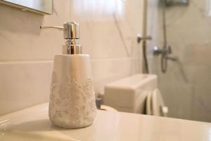 a white soap dispenser sitting on a sink in a bathroom at Zadar Kali Booking Franov Residence on island Ugljan with the pool, BBQ and beautiful sea-view! in Kali +116 photos