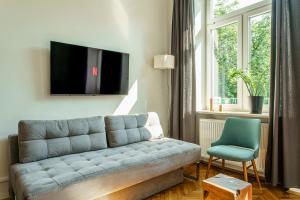 a living room with a couch and a chair at NOVUMHOUSE - Straszewskiego in Kraków