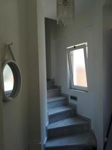 a stairway with a mirror and a window at Home 4you in Karlovasi