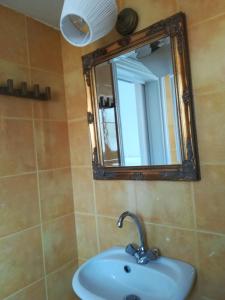 ein Bad mit einem Waschbecken und einem Spiegel in der Unterkunft Home 4you in Karlovasi