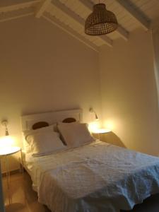 um quarto com uma cama branca e 2 candeeiros em Home 4you em Karlovasi