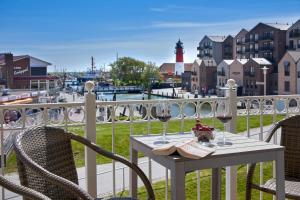 a table with two glasses of wine and a lighthouse at Haus EbenEzer in Büsum