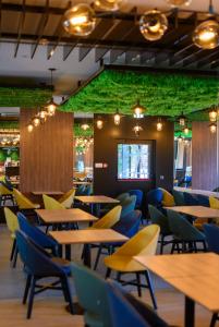a restaurant with tables and chairs and a green wall at Hotel Salis in Tuzla