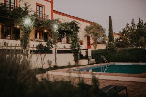 una casa con piscina frente a un edificio en Hotel Posada de Valdezufre, en Aracena