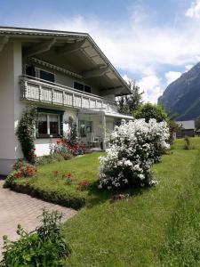 a house with a balcony and flowers in the yard at Apartment Dietrich Sylvia in Mellau