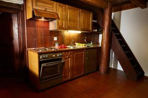 een keuken met houten kasten, een fornuis en een trap bij Wild Valley Romantic Escape in Crana