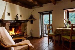 a living room with a fireplace and a table and a table and chairs at Wild Valley Romantic Escape in Crana