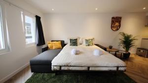 een slaapkamer met een bed en een bank bij Spacious 65m2 Apartment in the Centre of Eindhoven in Eindhoven