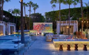 a resort with a pool and palm trees at night at Viceroy Santa Monica in Los Angeles