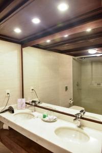 baño con 2 lavabos y espejo grande en Resort Yacht Y Golf Club Paraguayo en Asunción