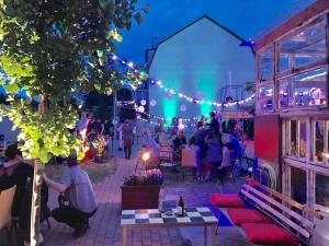 eine Gruppe von Menschen, die nachts auf einer Terrasse sitzen in der Unterkunft AMPELHAUS® in Oranienbaum-Wörlitz