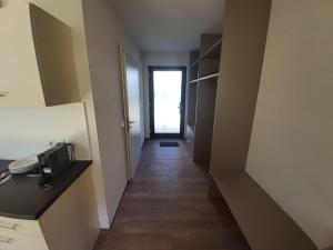 a hallway leading to a room with a door and a kitchen at Boardinghouse Donau Lodge in Donaueschingen