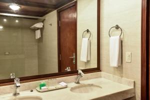 a bathroom with a sink and a large mirror at Resort Yacht Y Golf Club Paraguayo in Asuncion