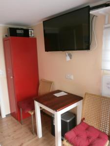 Zimmer mit einem Tisch und einem TV an der Wand in der Unterkunft Sportboot Zander in Bornheim