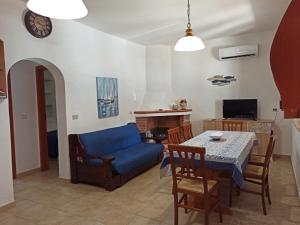 a living room with a table and a blue couch at Casa Volcanalia in Vulcano