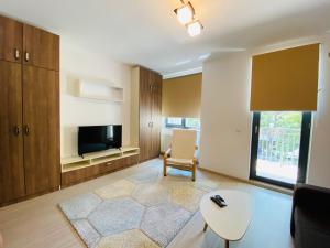 a living room with a couch and a tv and a table at Lira Holiday Apartments in Eforie Nord