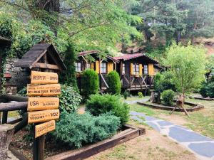 un cartel de madera frente a una cabaña de madera en La Posada Cercedilla, en Cercedilla