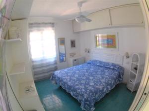 a bedroom with a blue bed and a window at Sea Beach Taormina Apartment in Letojanni