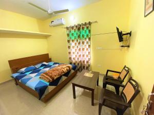 a bedroom with a bed and a table and a chair at TOURIST LODGE in Surajpur Jikkla