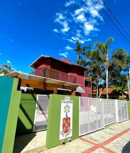 um edifício com uma vedação e um sinal em frente em Vila Figueiredo das Donas em Bombinhas