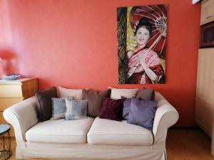 uma sala de estar com um sofá branco em frente a um quadro em Gite Habsiger em Ottrott