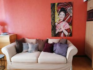 a living room with a white couch in front of a painting at Gite Habsiger in Ottrott