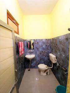 a bathroom with a toilet and a sink at TOURIST LODGE in Surajpur Jikkla