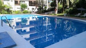 - une piscine d'eau bleue en face d'un bâtiment dans l'établissement Skol 913A by Completely Marbella, à Marbella