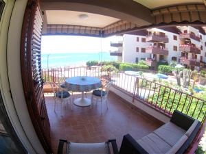 a balcony with a table and chairs and a view of the ocean at Sea Beach Taormina Apartment in Letojanni