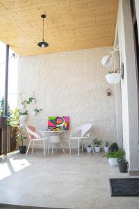 un patio con sillas y una mesa con una pintura en 4 Rooms en Sighnaghi