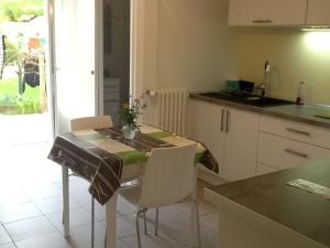 - une cuisine avec une table, des chaises et un comptoir dans l'établissement Le Clos Doménat 1, à Brive-la-Gaillarde