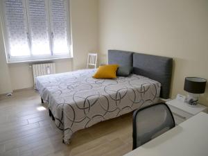 a bedroom with a bed with a yellow pillow on it at Flat 61 in Turin