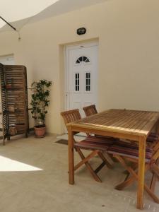 a dining room with a wooden table and chairs at Apartmani Kronjac in Milna