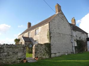 an old stone house with a stone wall at Lellizzick Farmhouse in Padstow +25 photos