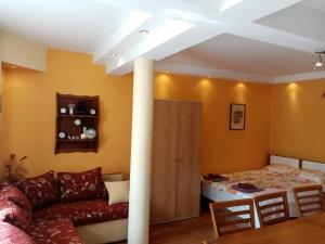 a living room with a couch and a bed at Guest House Prodanov in Sozopol