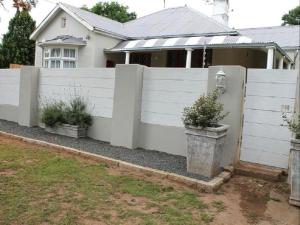 a white fence in front of a house at Lavender Lane Queenstown in Queenstown