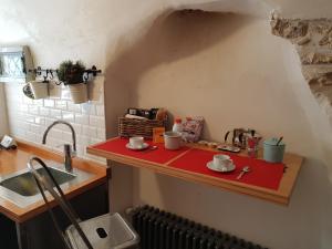 eine Küchentheke mit Tassen und Untertassen darauf in der Unterkunft LA CASA DI ROSA in Rivisondoli