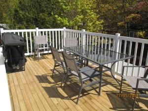 a glass table and chairs on a wooden deck at Executive Suites Bathurst in Bathurst