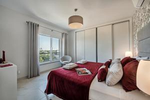 a bedroom with a large bed with a red bedspread at Apartamento Markus in Tavira