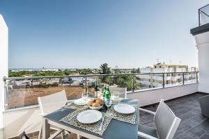 a dining table and chairs on a balcony with a view at Apartamento Markus in Tavira