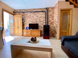 a living room with a table and a tv at APARTAMENTO TURISTICO NAVALINDA in Casas del Monte