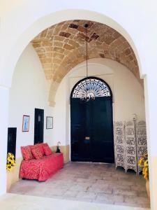 a room with a red couch in front of a black door at Il Giardino Segreto in Lizzanello
